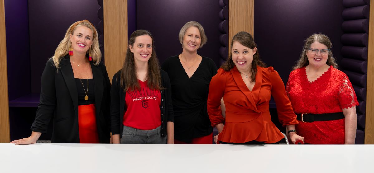The Office of Students with Disabilities staff pose in front of the study booths just outside their new office location: L1750. Pictured left-to-right: Patty Wallsch, Lauren Clark, Geri Wilson, Kayla Allen, and Shelly Oliver. All are wearing red and black for Normandale’s colors. 